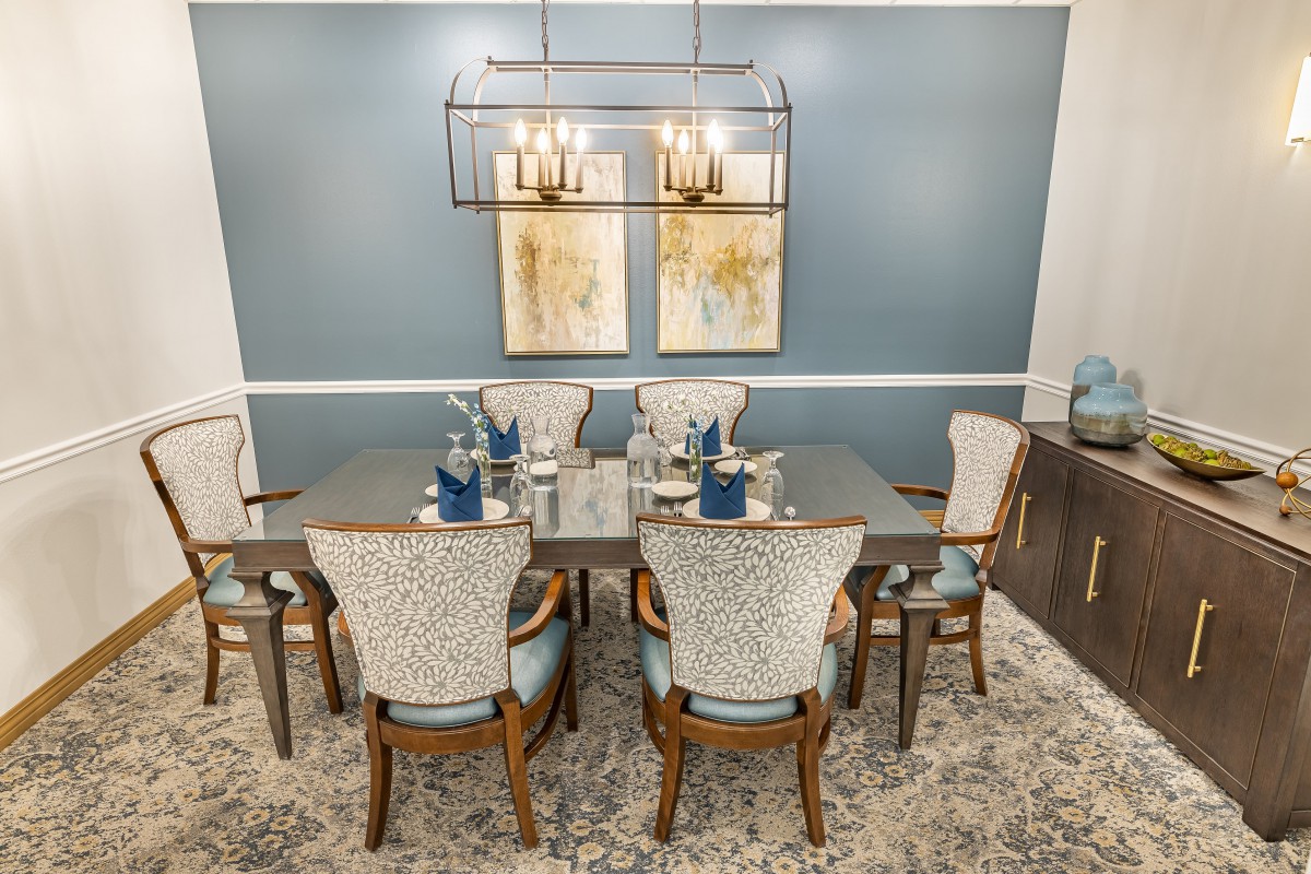A beautifully decorated dining room featuring an elegant table setting, modern chandelier, and stylish artwork.