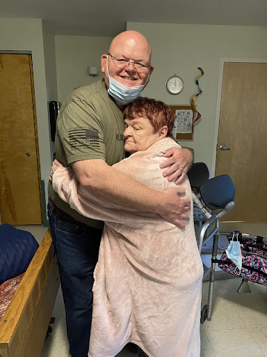 A heartfelt embrace shared between a caregiver and an elderly individual, symbolizing warmth and companionship.