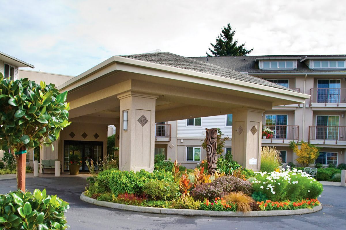 Main entrance of a building surrounded by landscaped gardens.