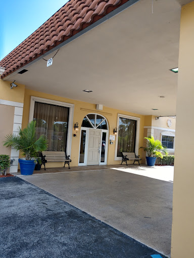 The welcoming entrance of a hotel featuring comfortable seating and tropical landscaping.