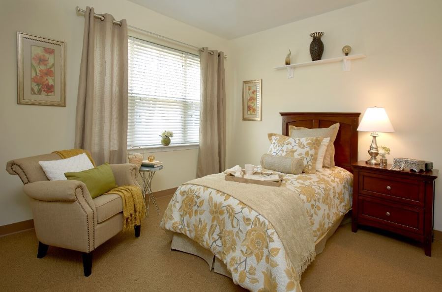 A cozy bedroom with a single bed, neutral decor, and armchair.