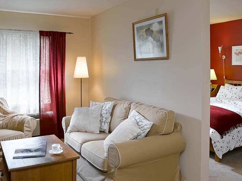 A cozy living room with a comfortable sofa, floor lamp, and a coffee table adorned with decor.