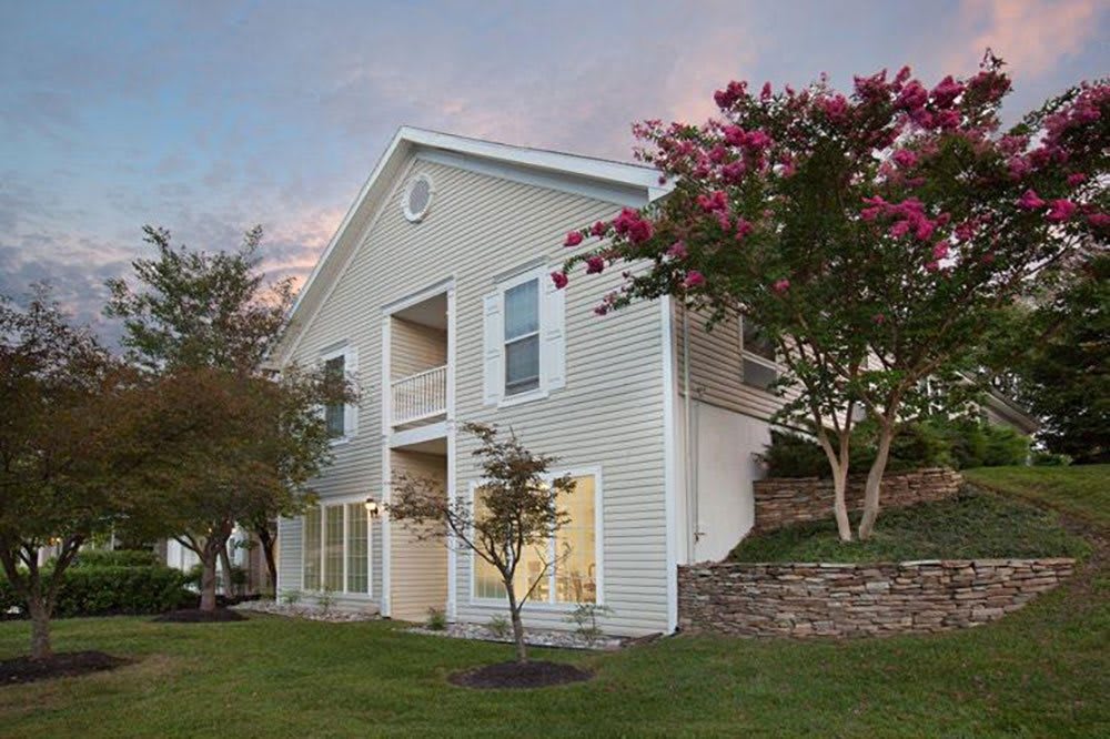 Two-story house with a garden at sunset.