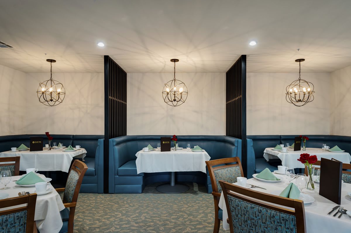 An elegant restaurant interior with booth seating and chandelier lighting.