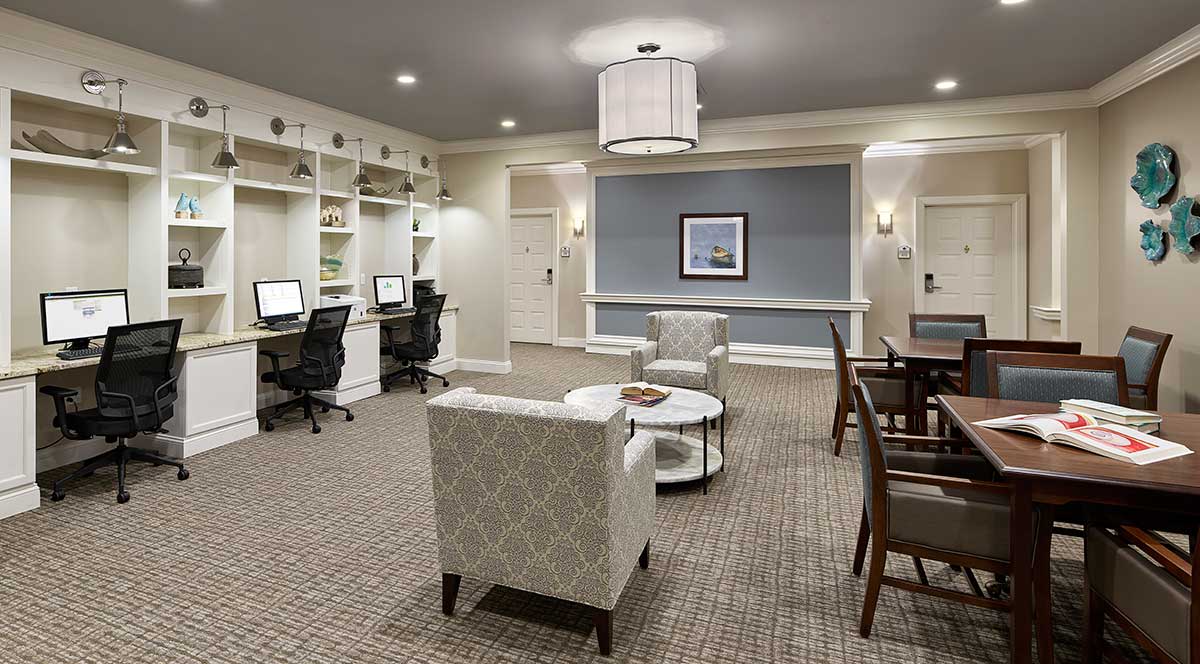 A modern office workspace featuring computers, seating areas, and stylish decor.