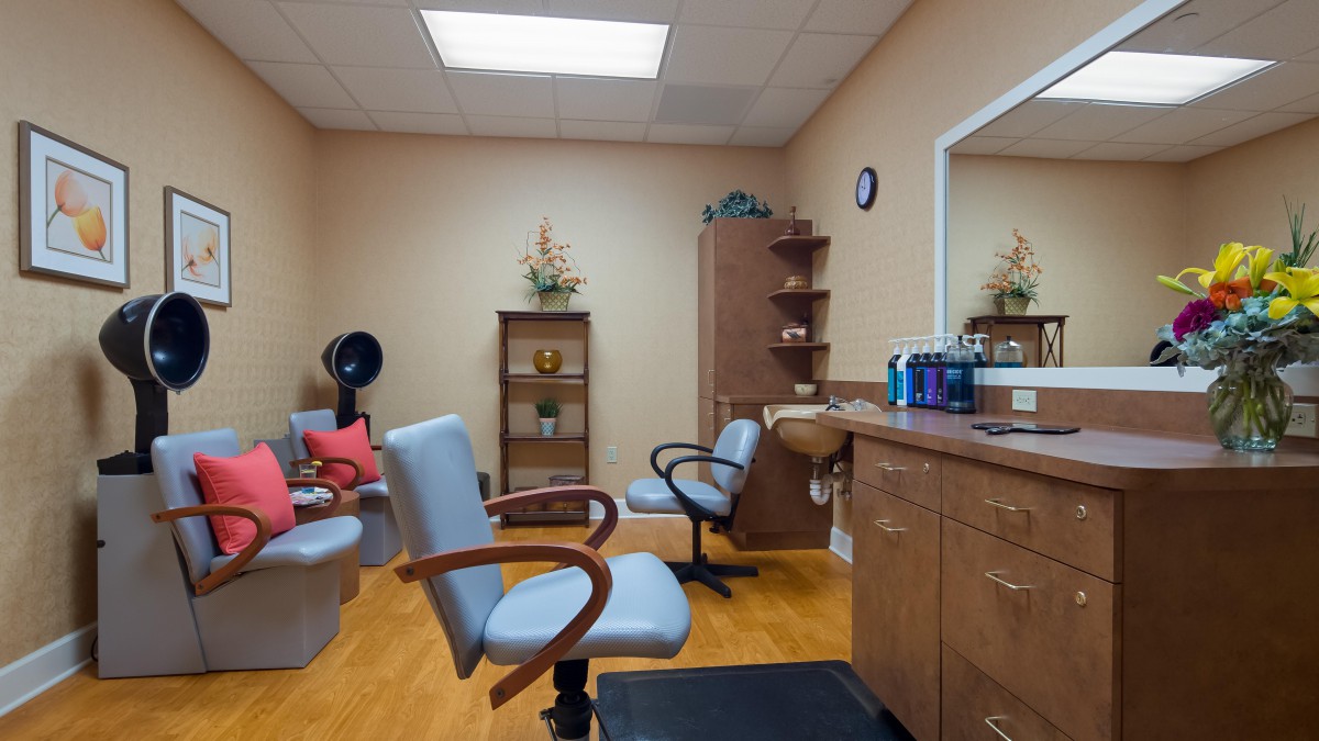A cozy hair salon interior with styling chairs and a variety of hair care products.