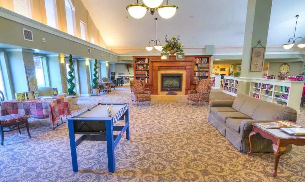 A cozy living room with a fireplace, bookshelves, and comfortable seating.