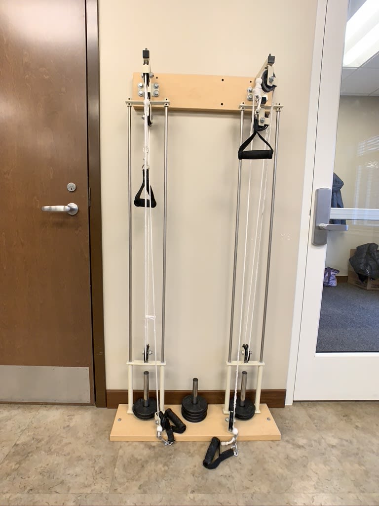 A wall-mounted cable machine in a fitness facility.