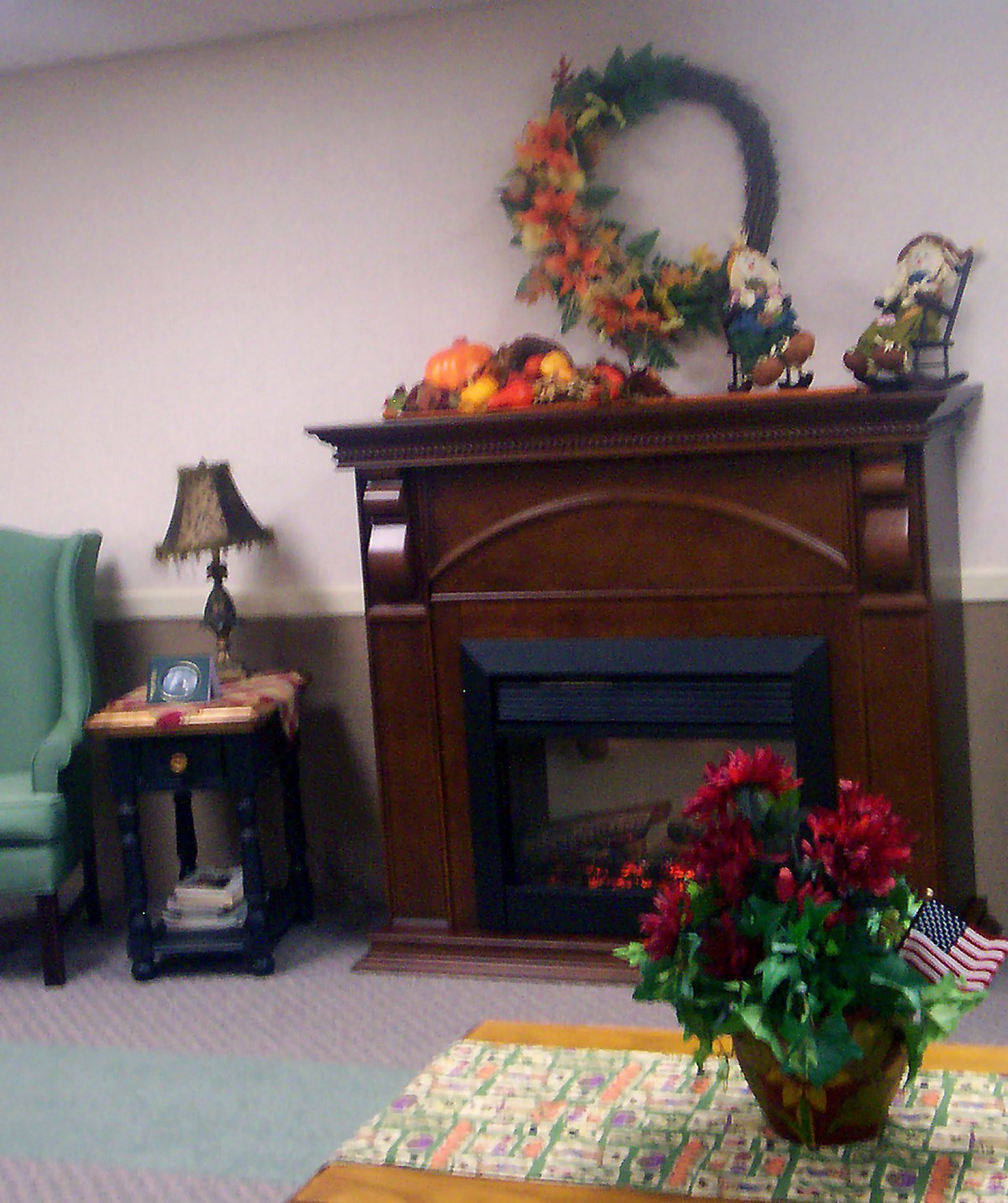 A cozy living room with a decorated fireplace and autumn accents.