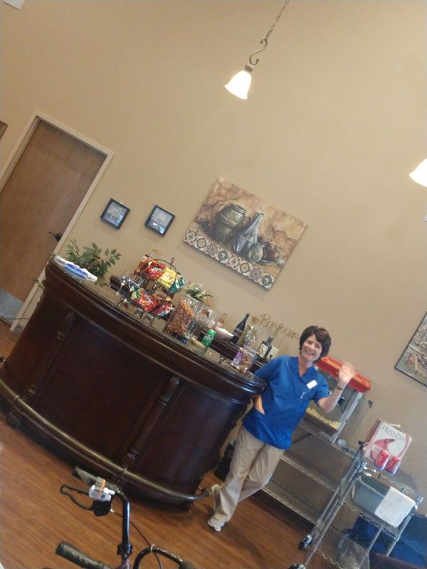 A person stands behind a reception desk decorated with balloons in an office setting.