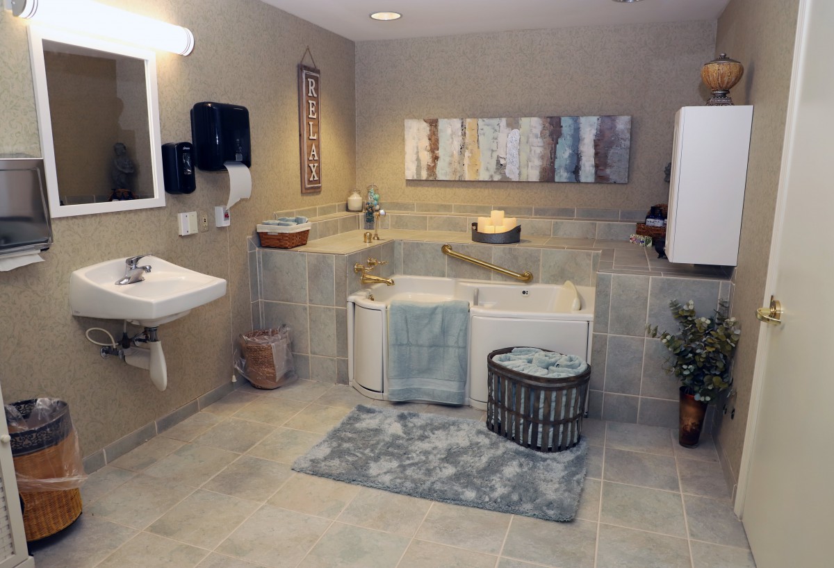 A modern bathroom with a corner bathtub, a wall-mounted sink, and stylish decor.