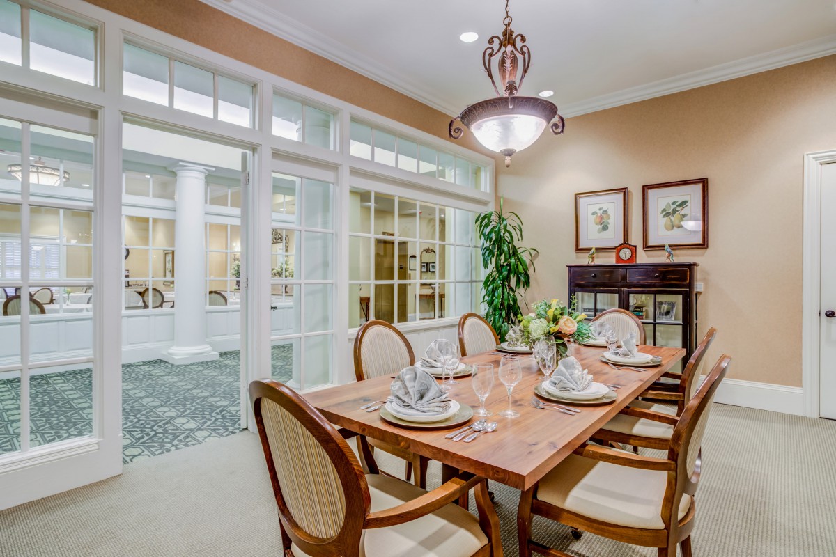 A beautifully furnished dining room with an elegantly set table and ambient lighting.