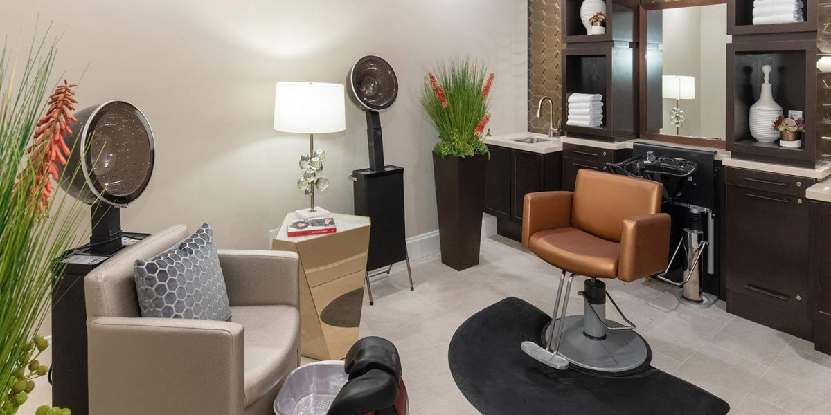 A modern salon interior featuring a hair styling chair, a lamp, and decorative elements.
