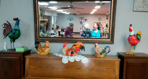 A lively dining area featuring decorative chickens on a wooden table and reflections in a mirror.