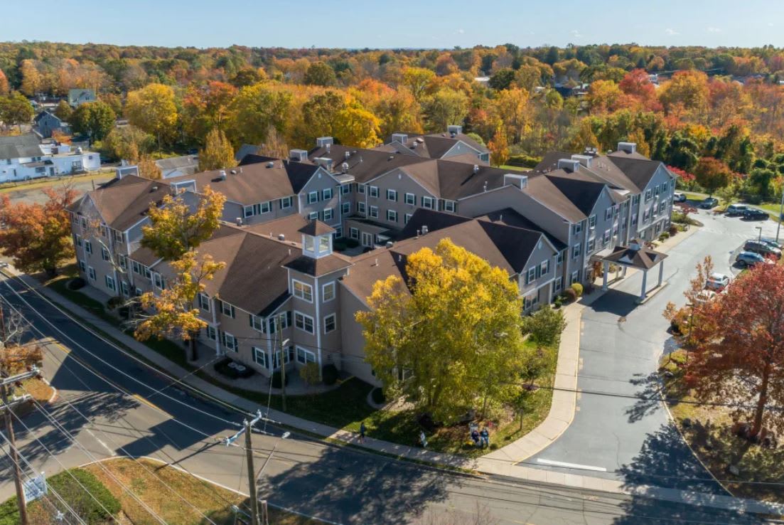 An aerial view of a suburban neighborhood surrounded by colorful autumn trees.