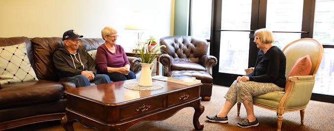 Two people engaged in a conversation in a cozy living room setting.