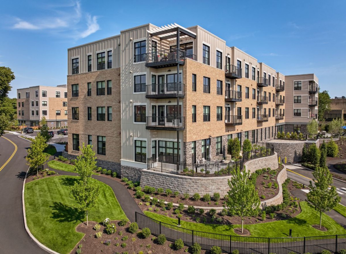 A modern residential apartment building with balconies and landscaped surroundings.
