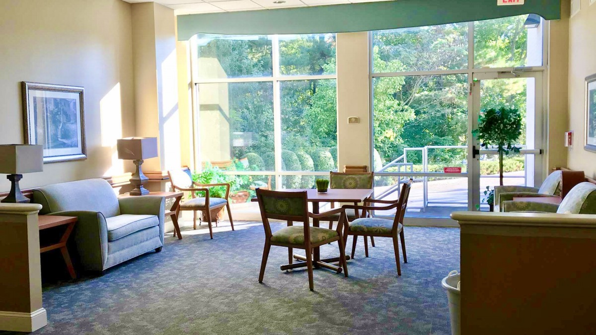 A spacious lounge area with modern furniture and large windows allowing natural light to flood in.
