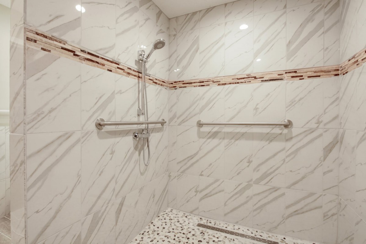 Modern bathroom with marble walls and a walk-in shower.