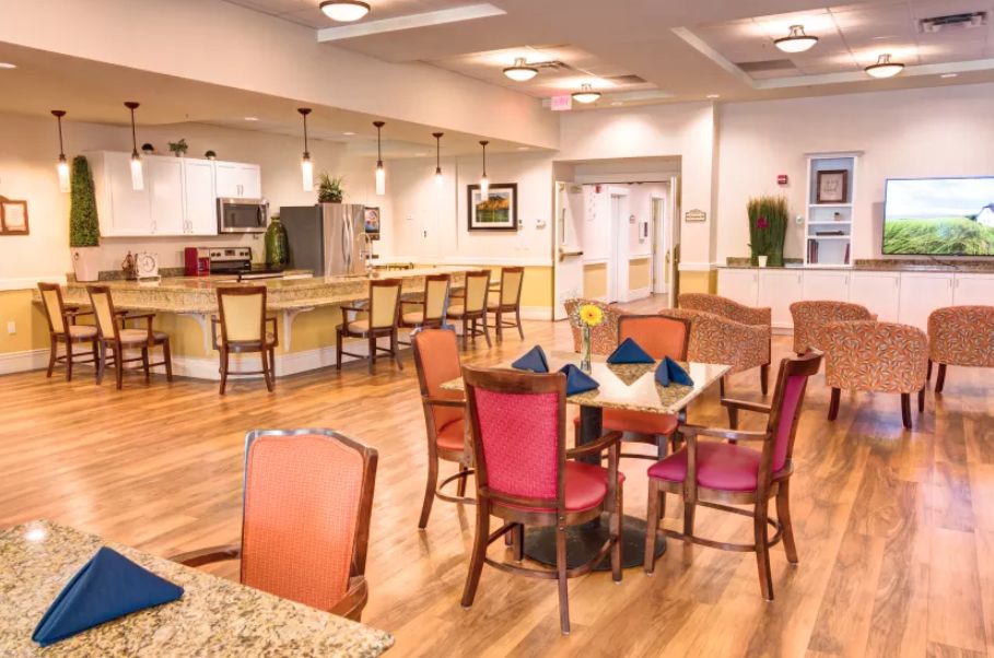 A spacious and well-lit dining area with a modern kitchen in the background.