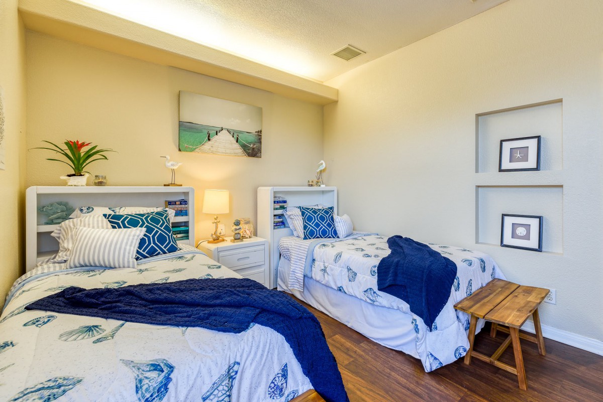 A cozy bedroom with twin beds featuring a coastal theme and blue accents.