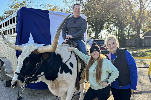 A fun day outdoors with family, riding a bull against the backdrop of a Texas flag.