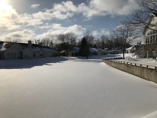A serene winter landscape covered in fresh snow, under a partly cloudy sky.