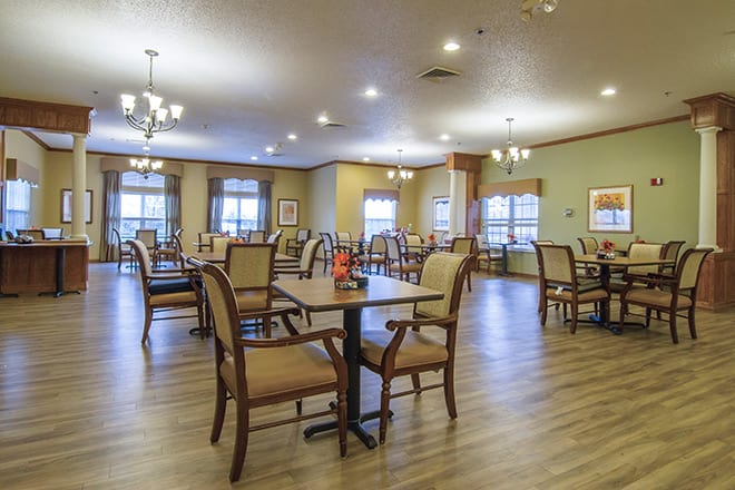 A spacious and well-lit dining room with arranged tables and chairs.