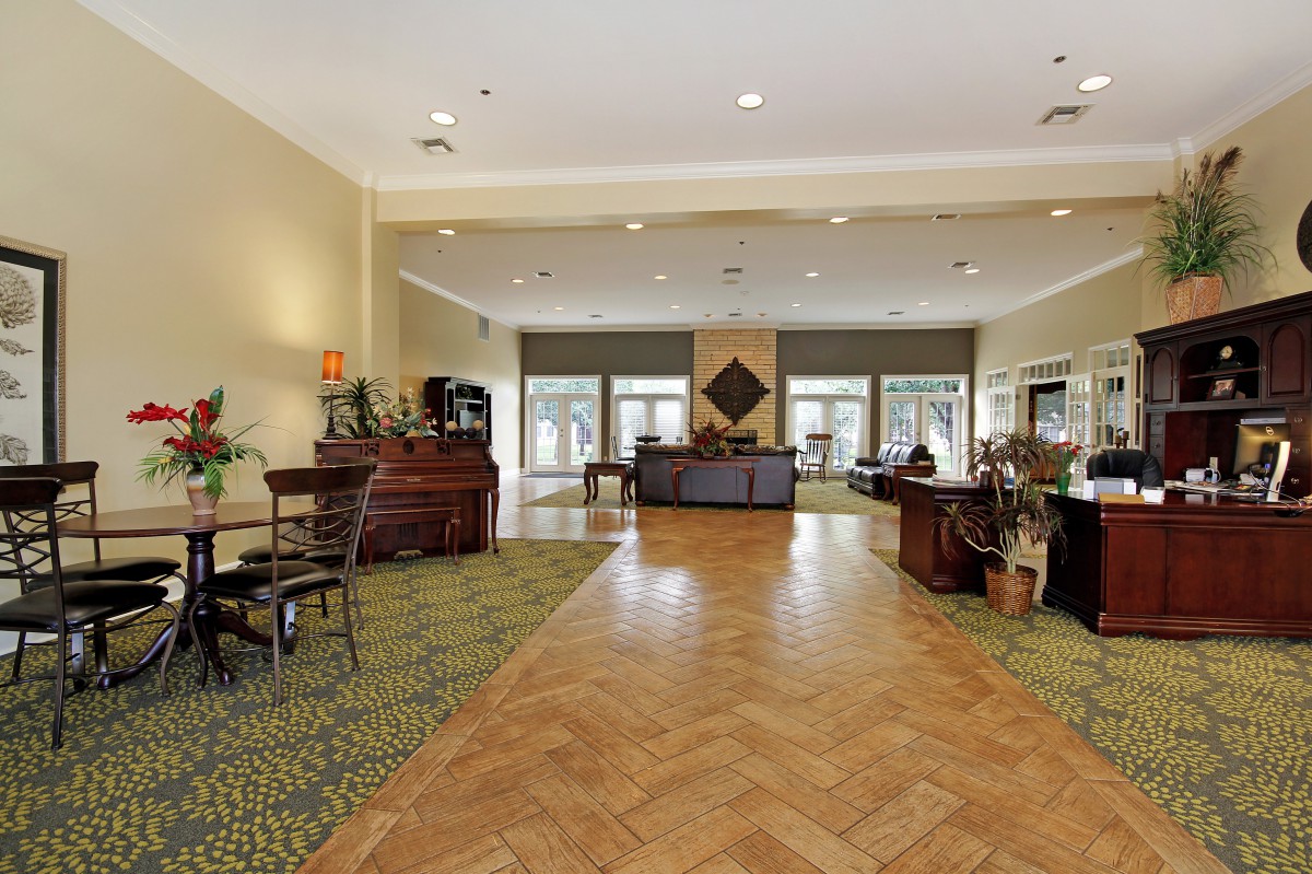 A spacious hotel lobby with a reception desk and seating area.