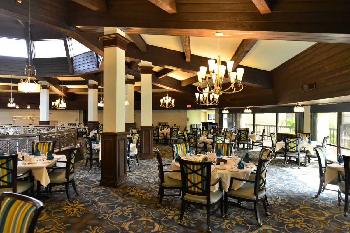 An elegantly designed dining room with chandeliers and neatly arranged tables.