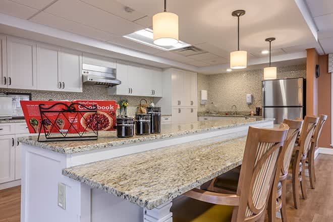 Modern kitchen with granite countertops and elegant lighting.