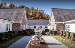 A symmetrical view of two brick buildings with a landscaped pathway in between.