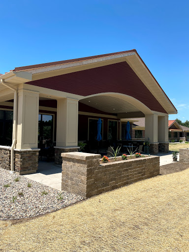 A modern architectural design featuring a spacious entrance and landscaped surroundings.