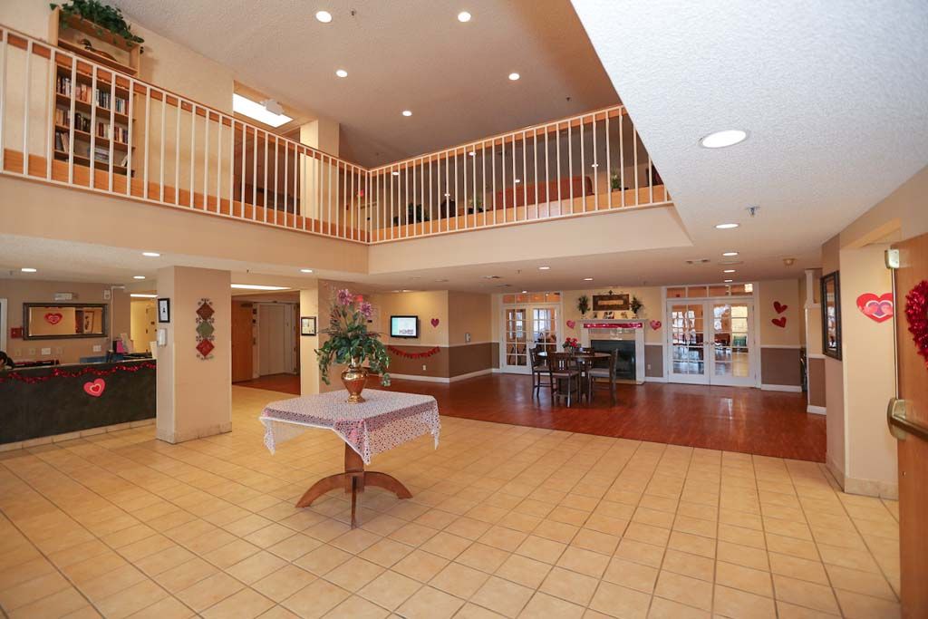 Spacious lobby area with a central table and upper level railing.