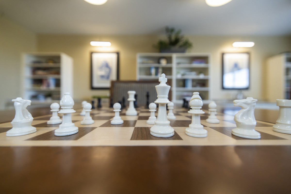 A chessboard set up for a strategic game in a cozy room.