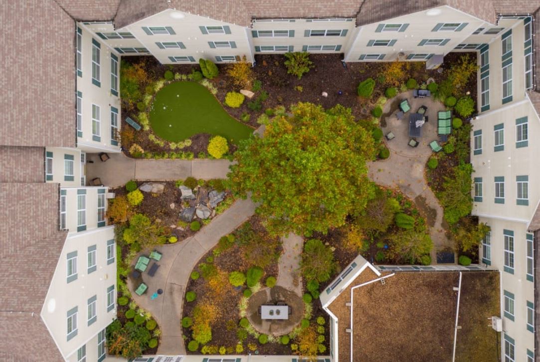 Aerial view of a building's courtyard with lush greenery and walking paths.