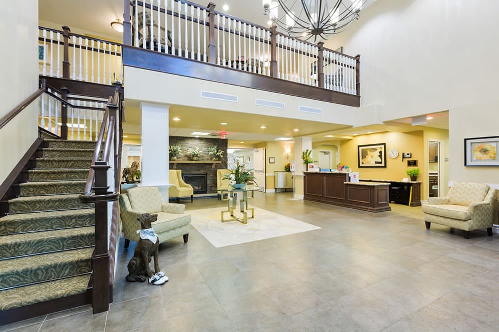 A luxurious lobby area featuring a grand staircase, elegant chandelier, and stylish furniture.