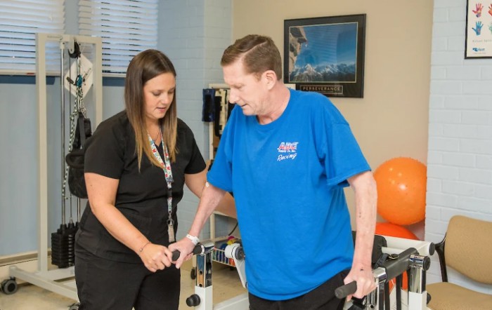 A therapist assists a patient during a physical rehabilitation session.