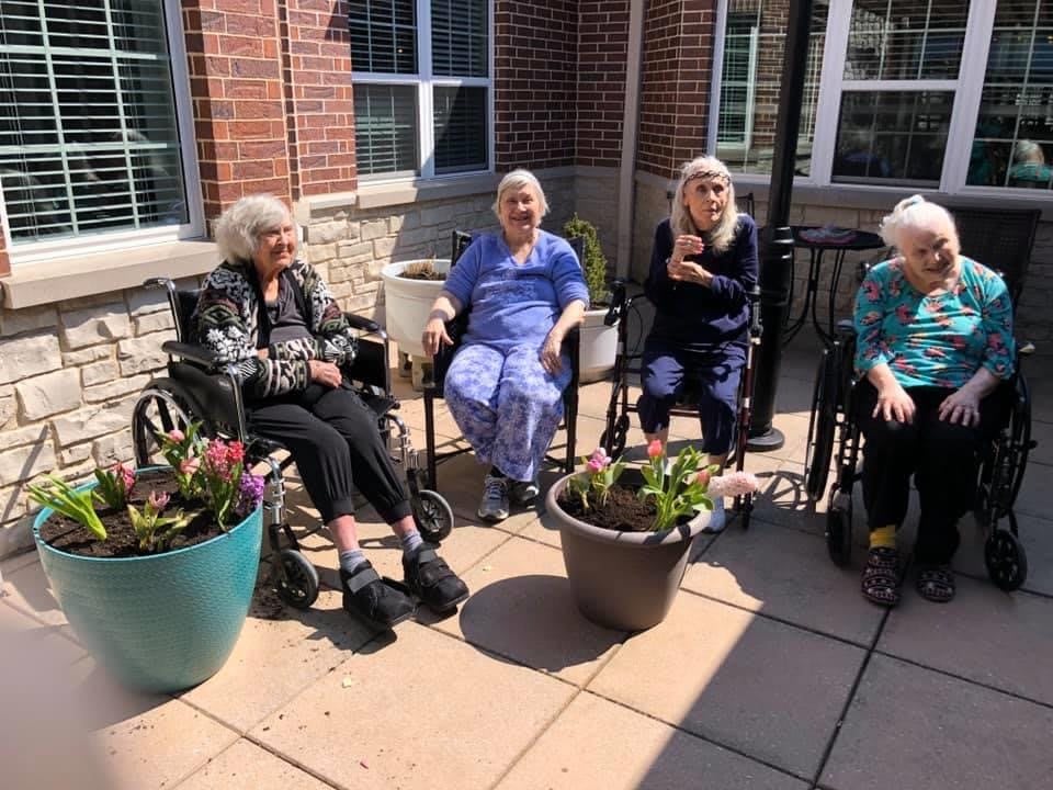A group of seniors enjoying the outdoors on a sunny patio.