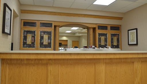 A modern reception area showcasing a wooden counter and a welcoming interior design.