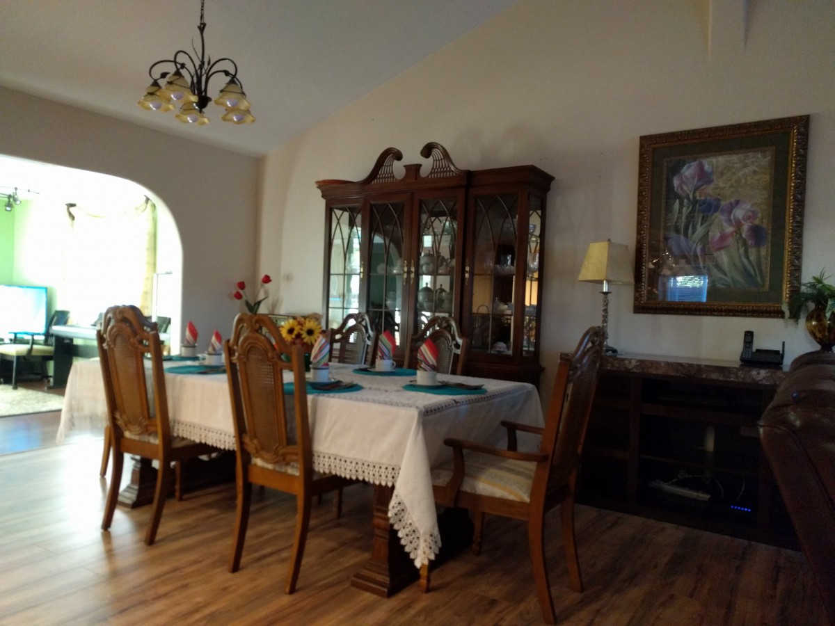 A cozy dining room with a set table and elegant furnishings.