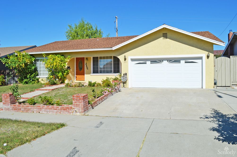 A suburban house with a garage and driveway on a clear day.