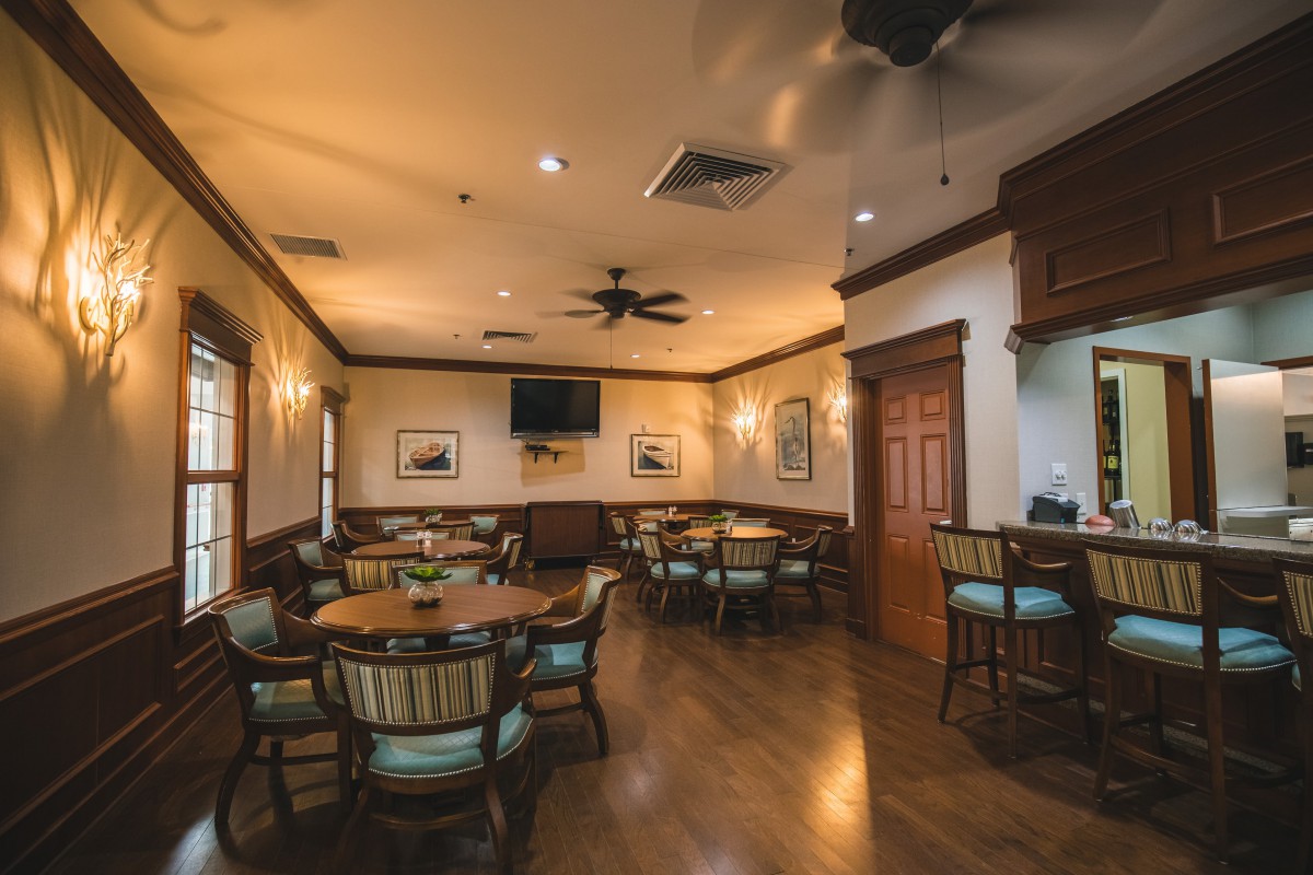 A cozy dining area with wooden floors and elegantly arranged tables and chairs.