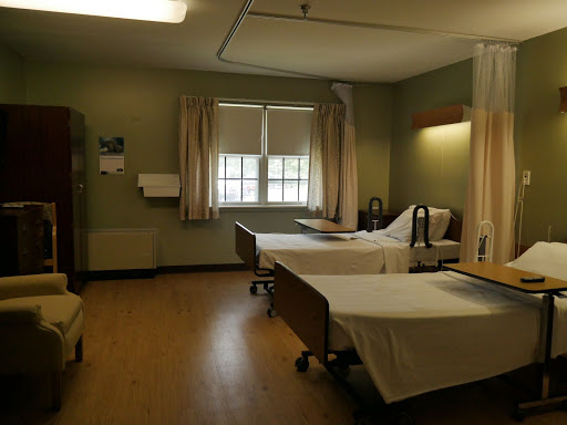 A peaceful hospital room with two patient beds and natural light coming through the windows.