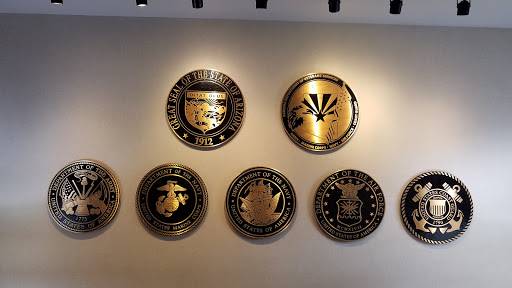 A display of various military seals mounted on a wall.