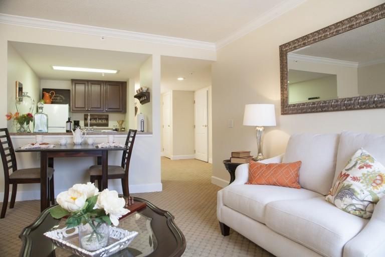 A modern open-concept living room with a view into the kitchen, featuring stylish furniture and decor.