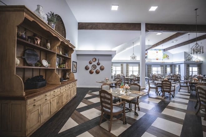 A cozy dining area with wooden furniture and decorative shelves.