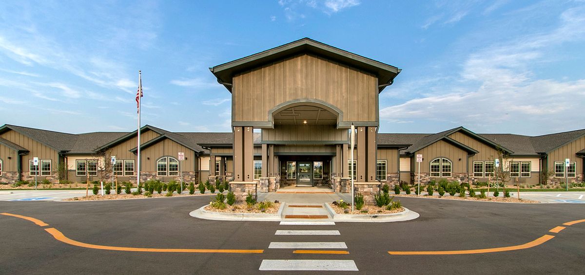 A modern building with a grand entrance and well-maintained landscaping.