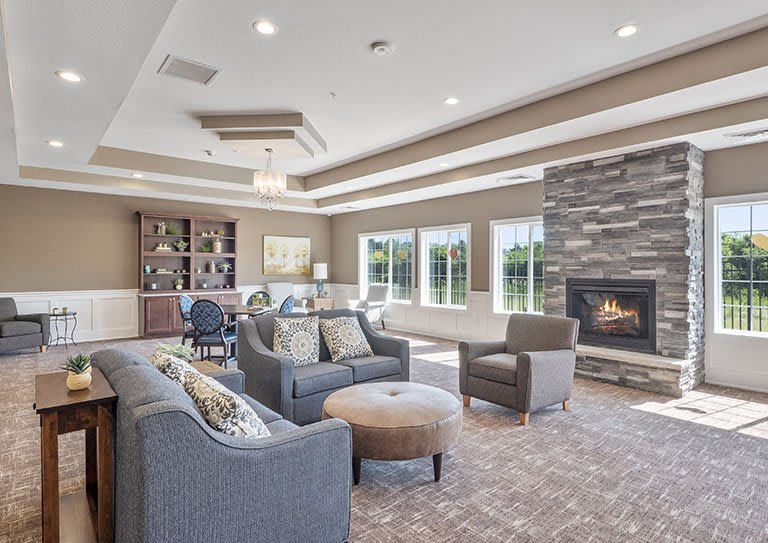 A cozy living room with comfortable seating, a fireplace, and large windows.