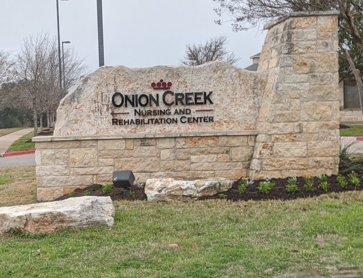 A stone entrance sign for Onion Creek Nursing and Rehabilitation Center.